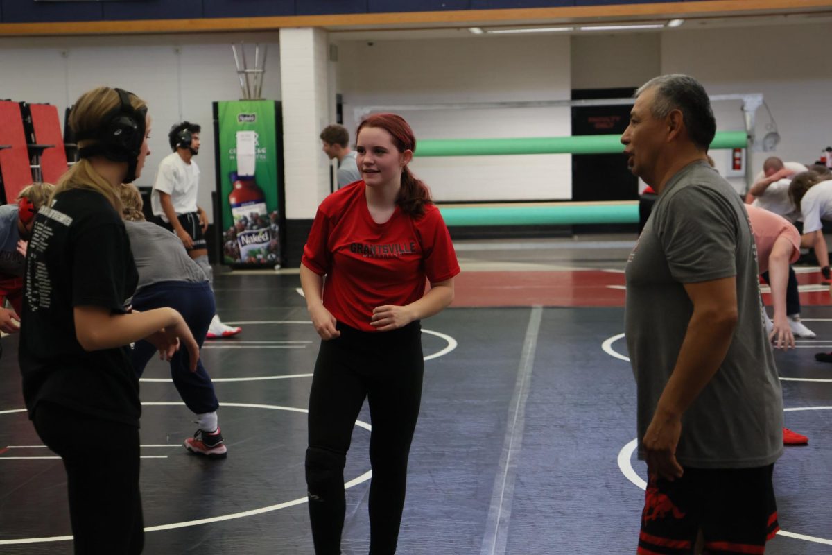 Coach Barry(right) helping two of the girls wrestlers 