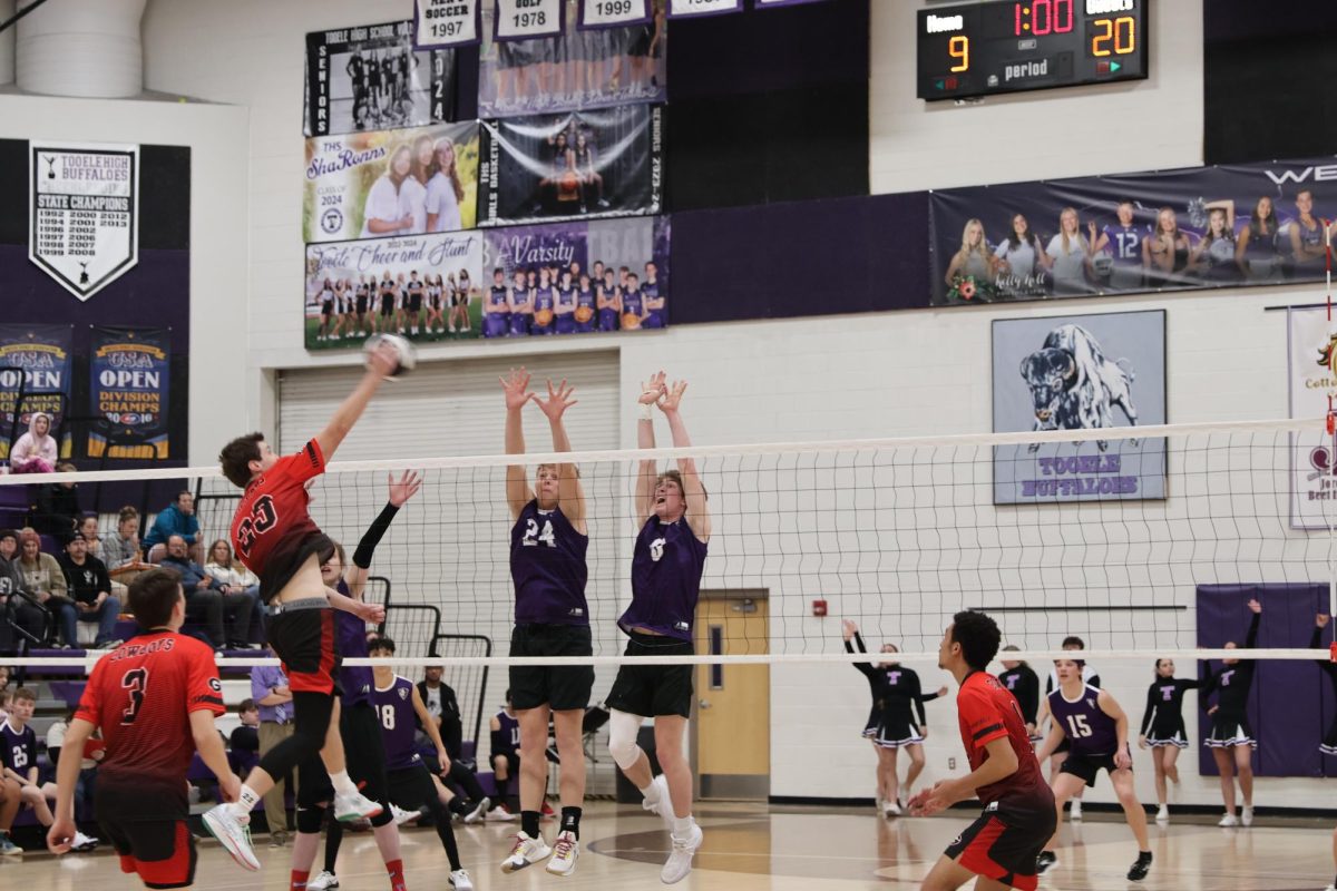 Corbin Hislop Spiking ball over Tooele High defenders 