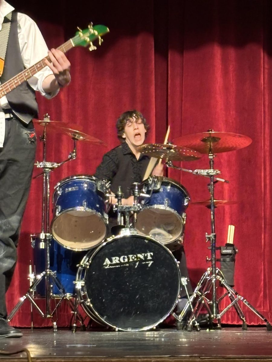 Rian Scott playing drums at the showcase.