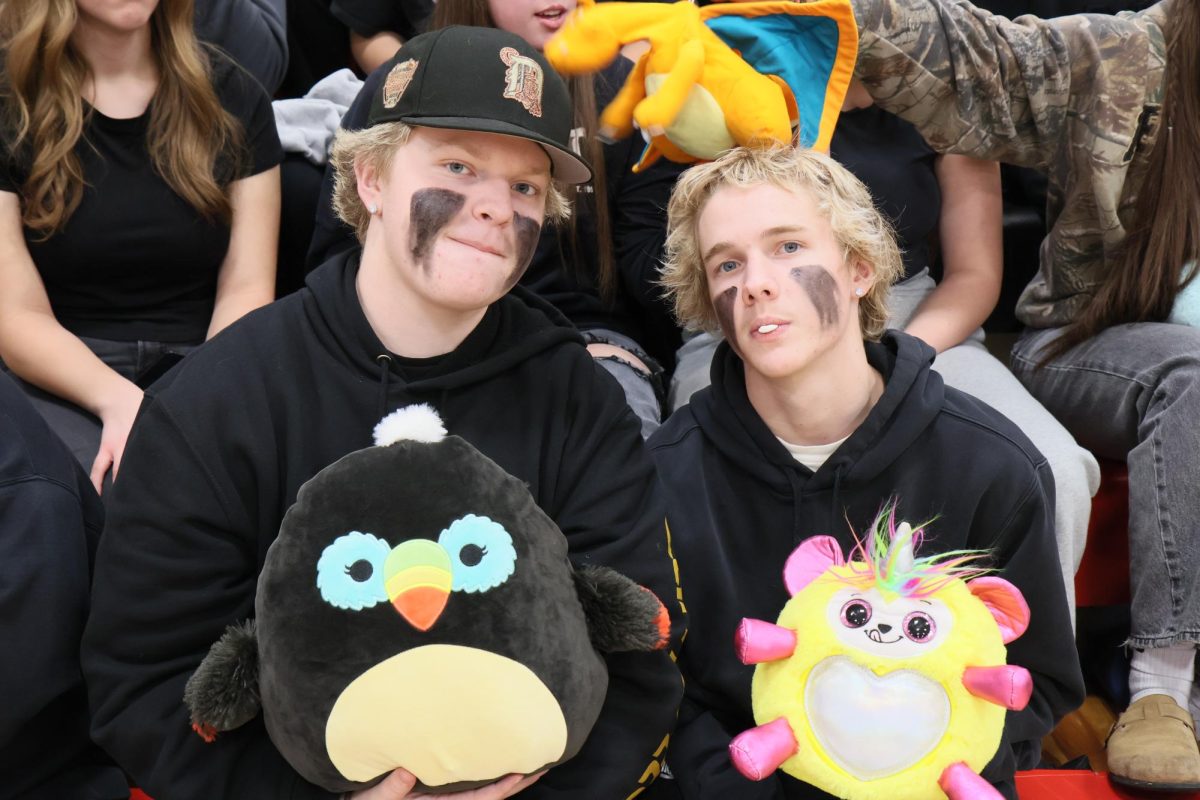 Cole sparks and Anthony Shultz in student section with stuffed animals for teddy bear toss